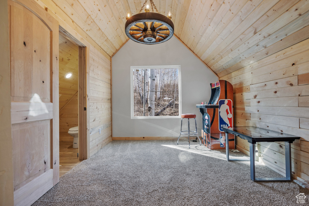 Bonus room featuring wood walls, wooden ceiling, lofted ceiling, carpet, and baseboards