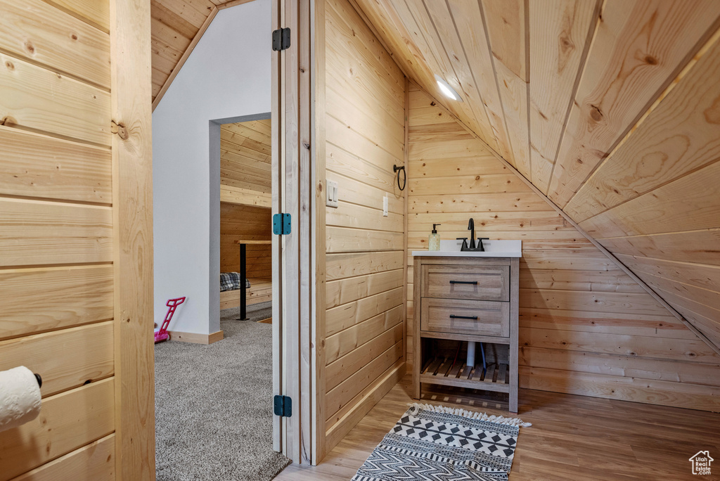 Bonus room with lofted ceiling, wood walls, and wooden ceiling