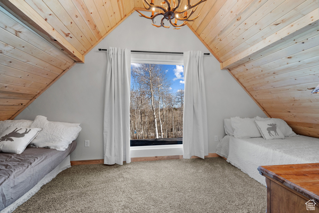Carpeted bedroom with a chandelier, wooden ceiling, lofted ceiling, and baseboards