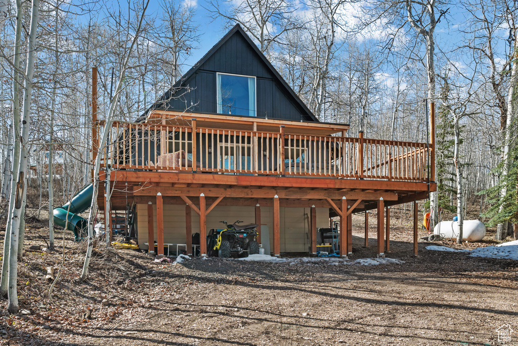 Back of property with a carport, a deck, and driveway