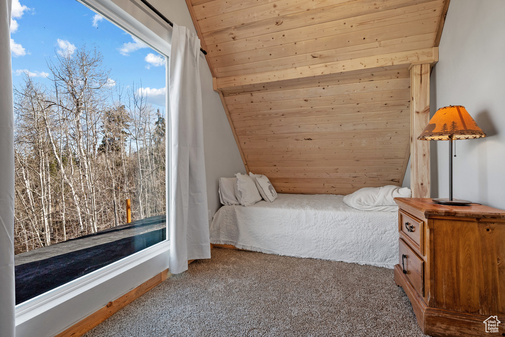 Bedroom featuring carpet, wooden ceiling, and vaulted ceiling