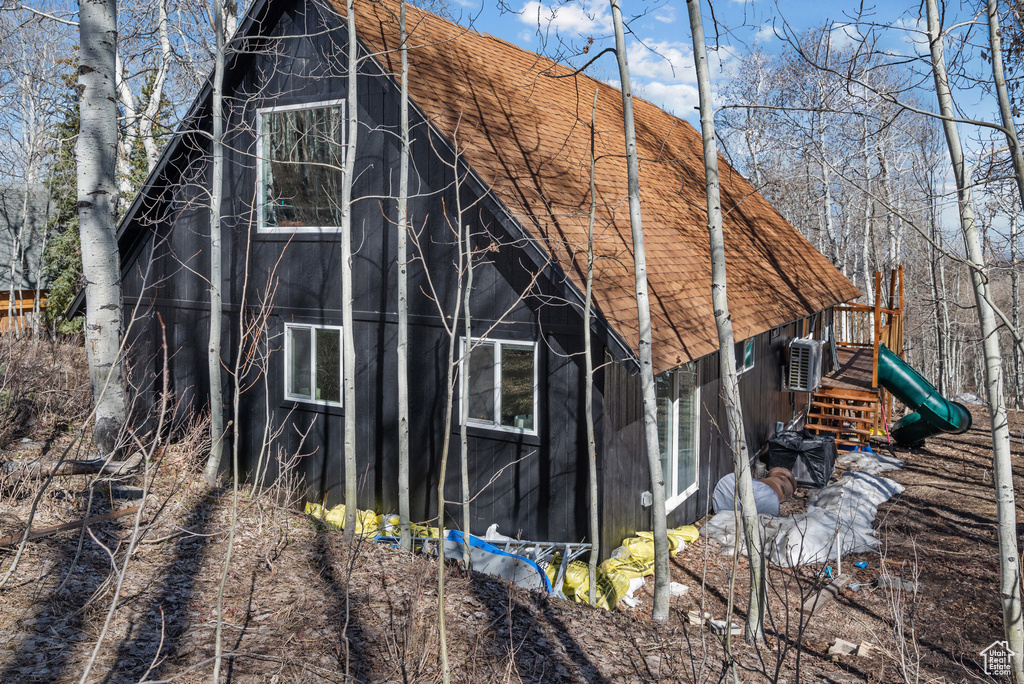 View of side of property with a shingled roof