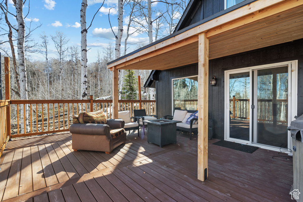 Wooden terrace with an outdoor living space with a fire pit