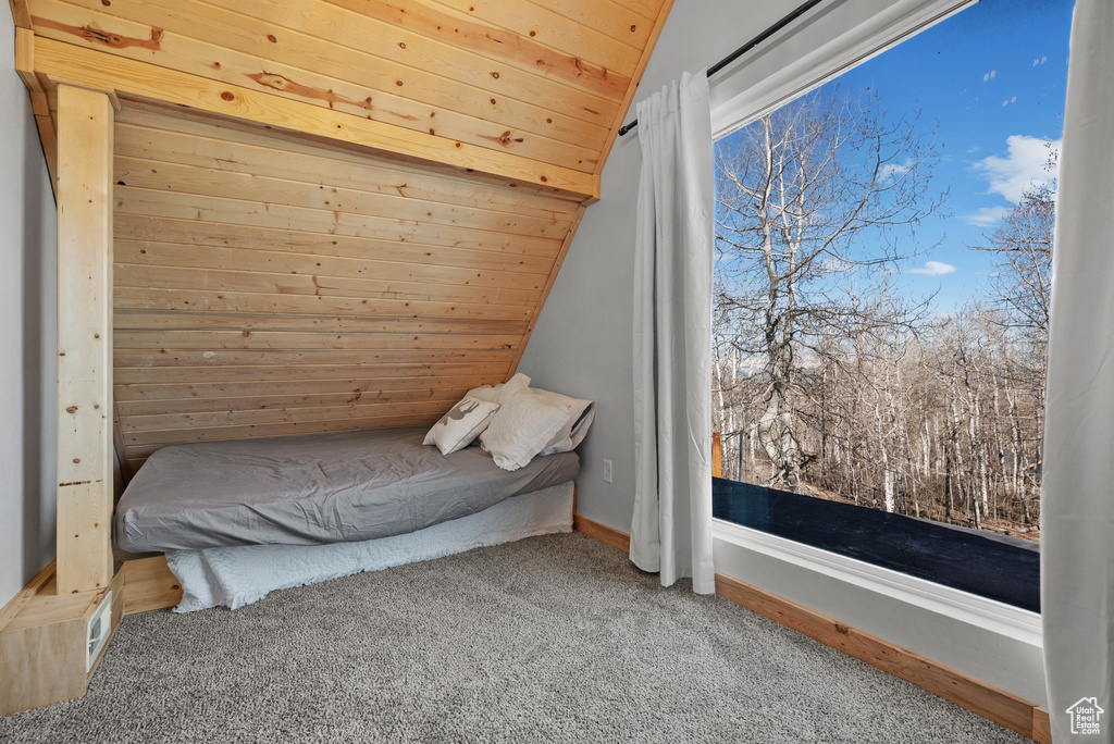 Bedroom with carpet floors, lofted ceiling, and wooden ceiling