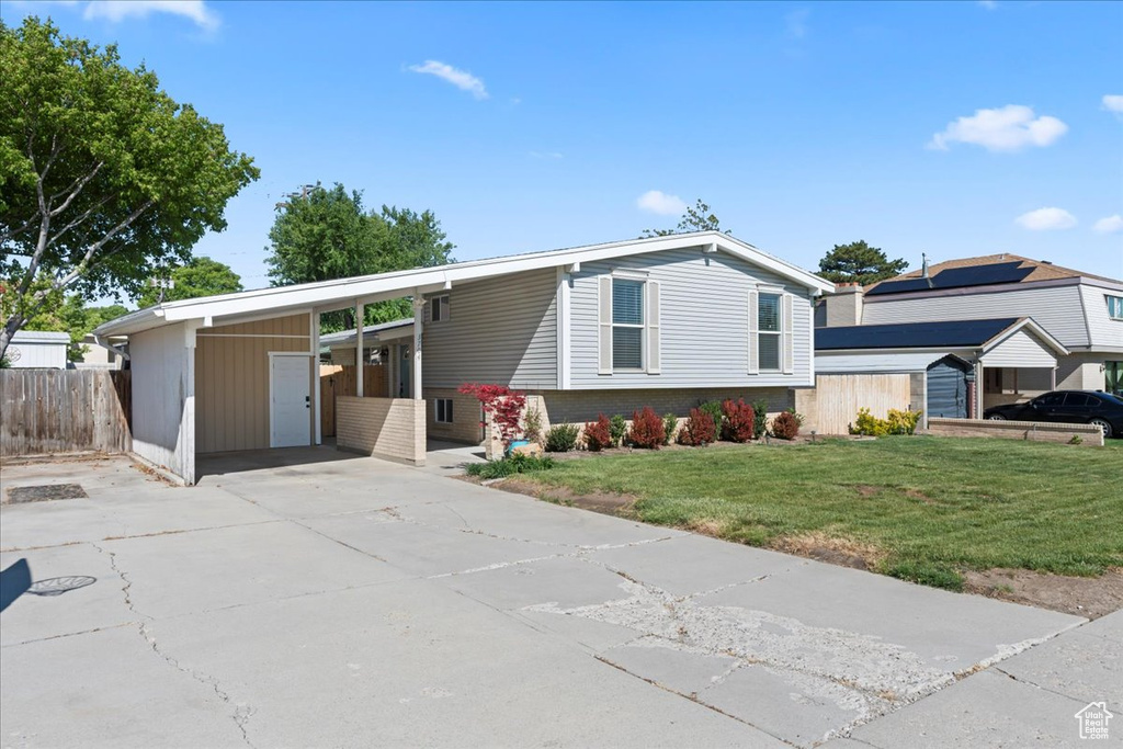 View of front of property featuring driveway, a carport, and brick siding