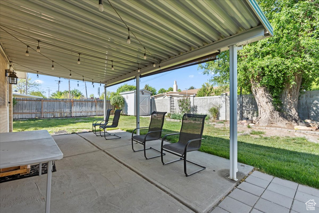 View of patio with a shed and an outbuilding