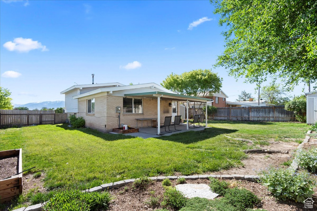 Back of property with brick siding and a patio