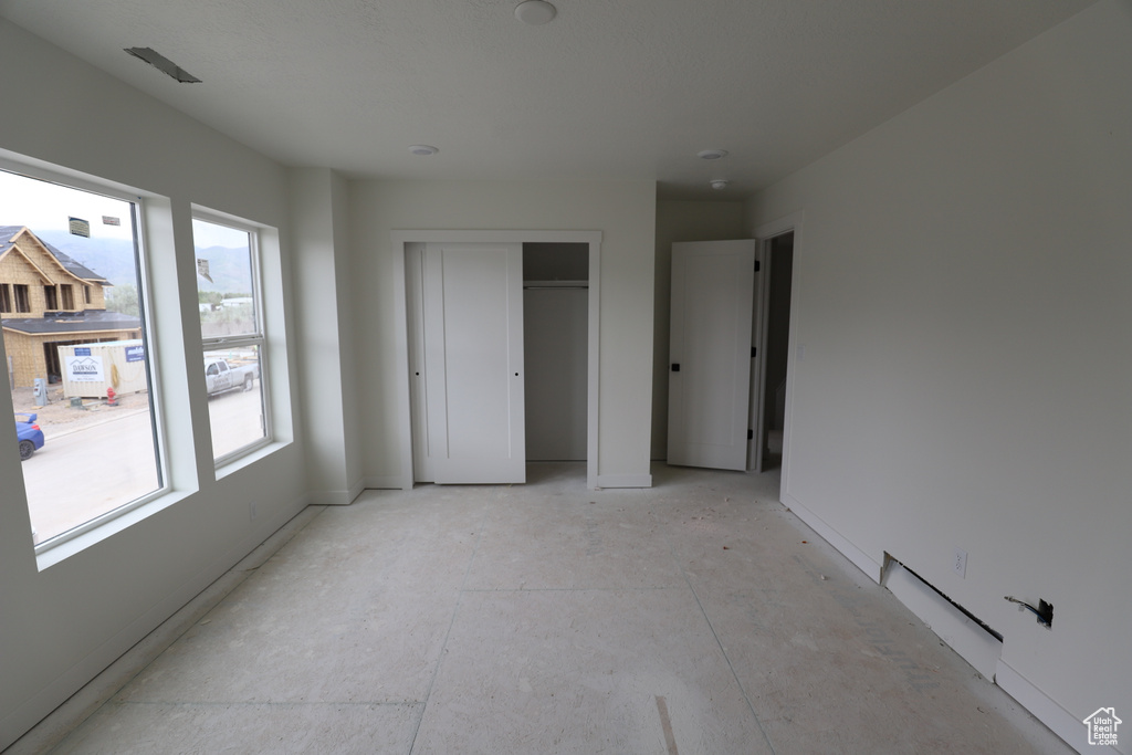Unfurnished bedroom with baseboards and a closet