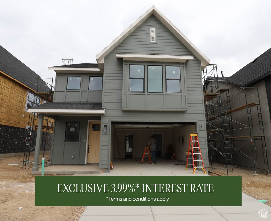 View of front of property featuring an attached garage and fence