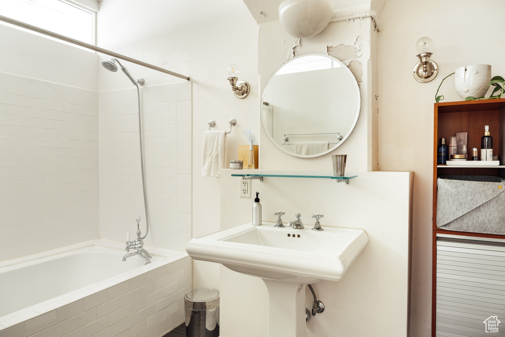 Bathroom with tiled shower / bath combo and a sink