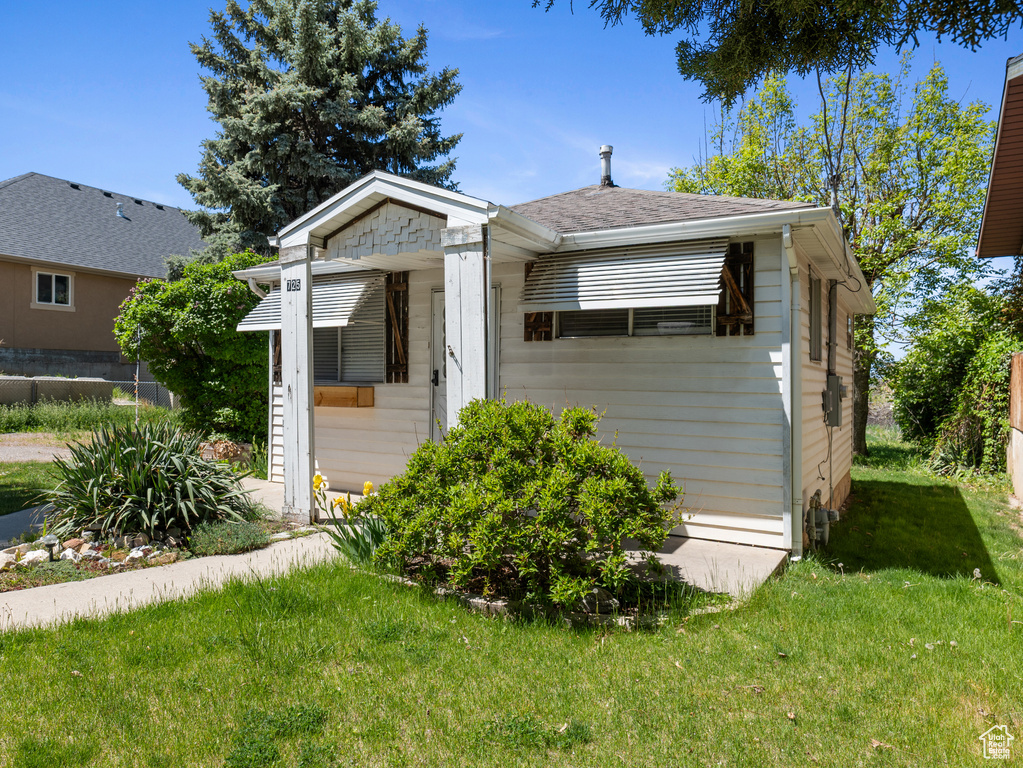 Bungalow-style house with a front lawn and a shingled roof