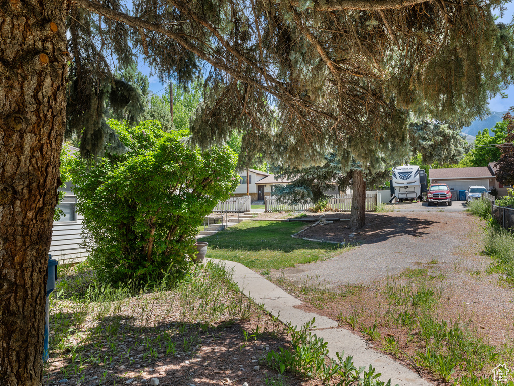 View of yard with fence and gravel driveway