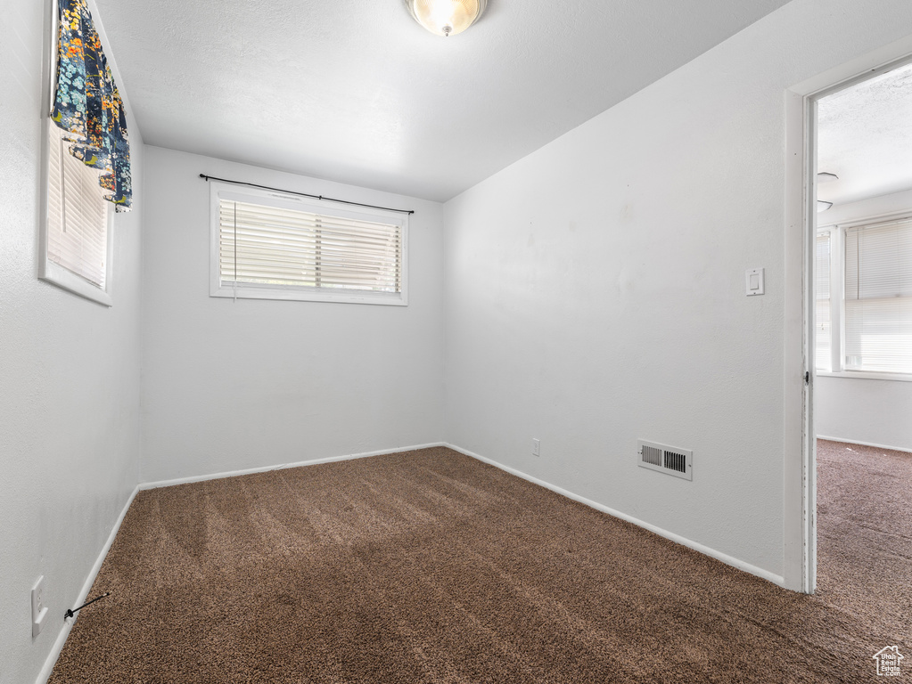 Carpeted spare room with baseboards