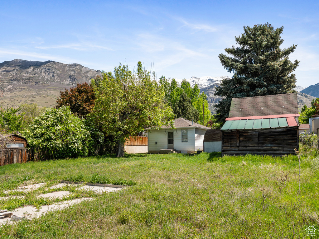 View of yard with a mountain view, a storage unit, and an outdoor structure