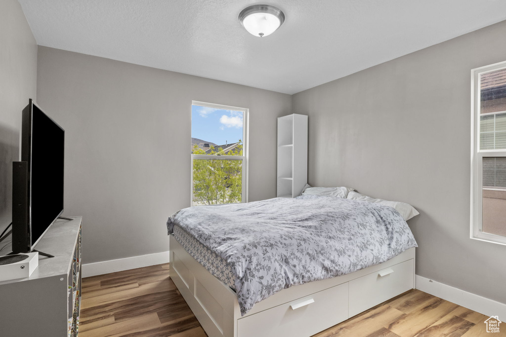 Bedroom with baseboards and wood finished floors