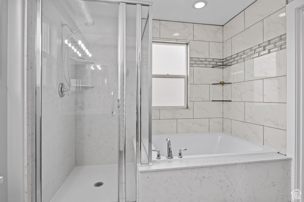 Full bathroom featuring a stall shower and a bath