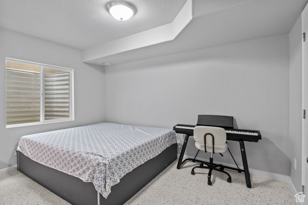 Bedroom featuring baseboards and speckled floor