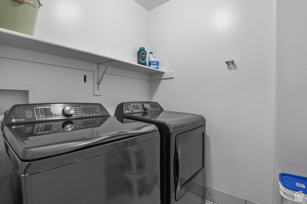 Laundry area featuring washing machine and dryer and baseboards