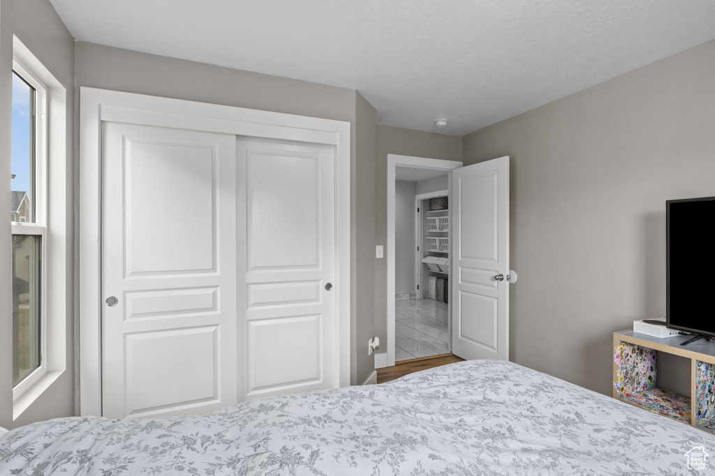Bedroom with a closet, baseboards, and wood finished floors