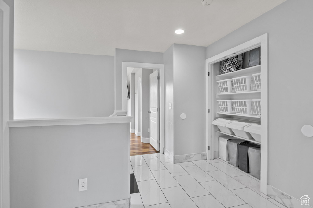 Hallway with baseboards, recessed lighting, and light marble finish floors