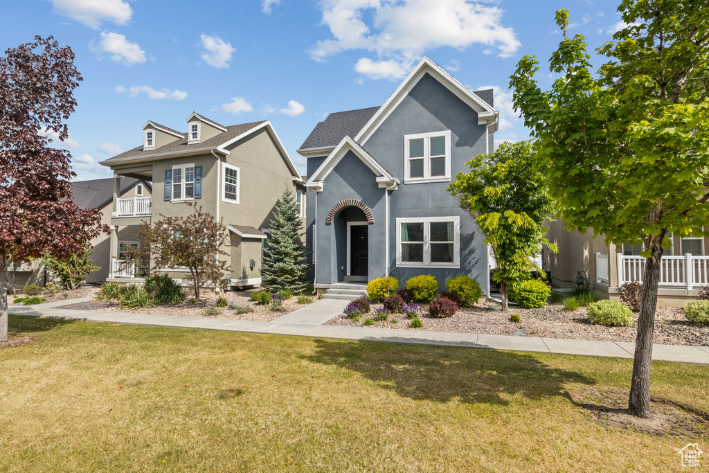 Traditional home featuring stucco siding and a front yard
