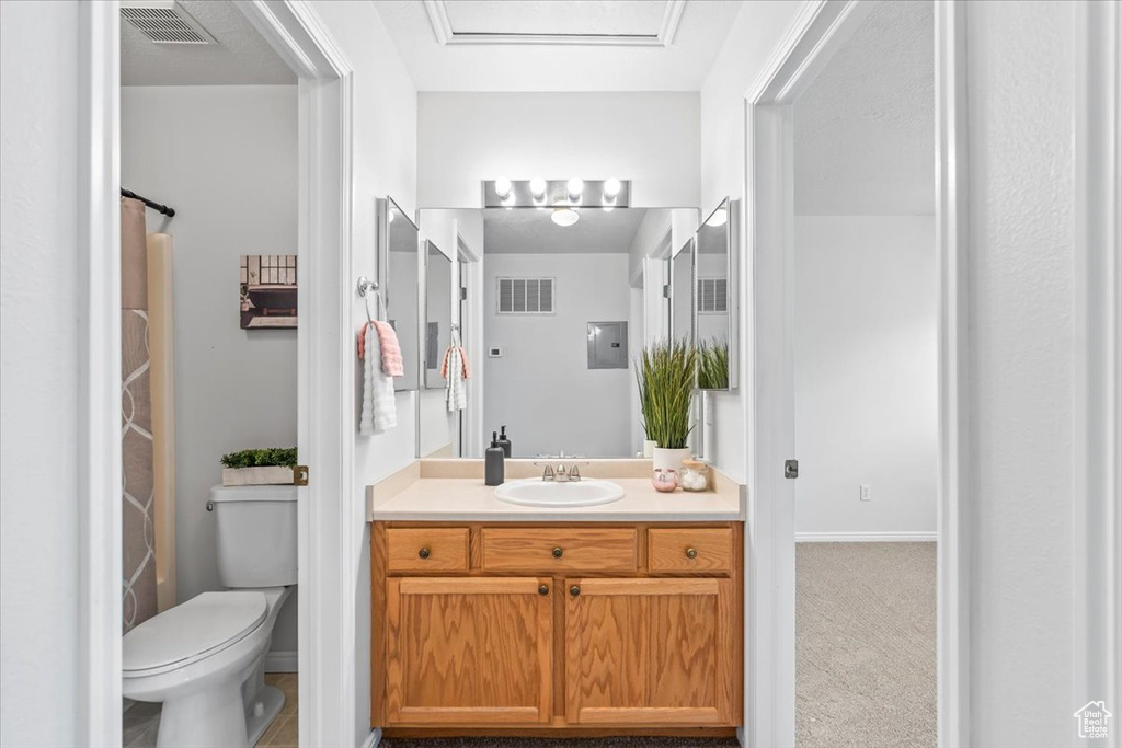 Full bath featuring vanity, toilet, and baseboards