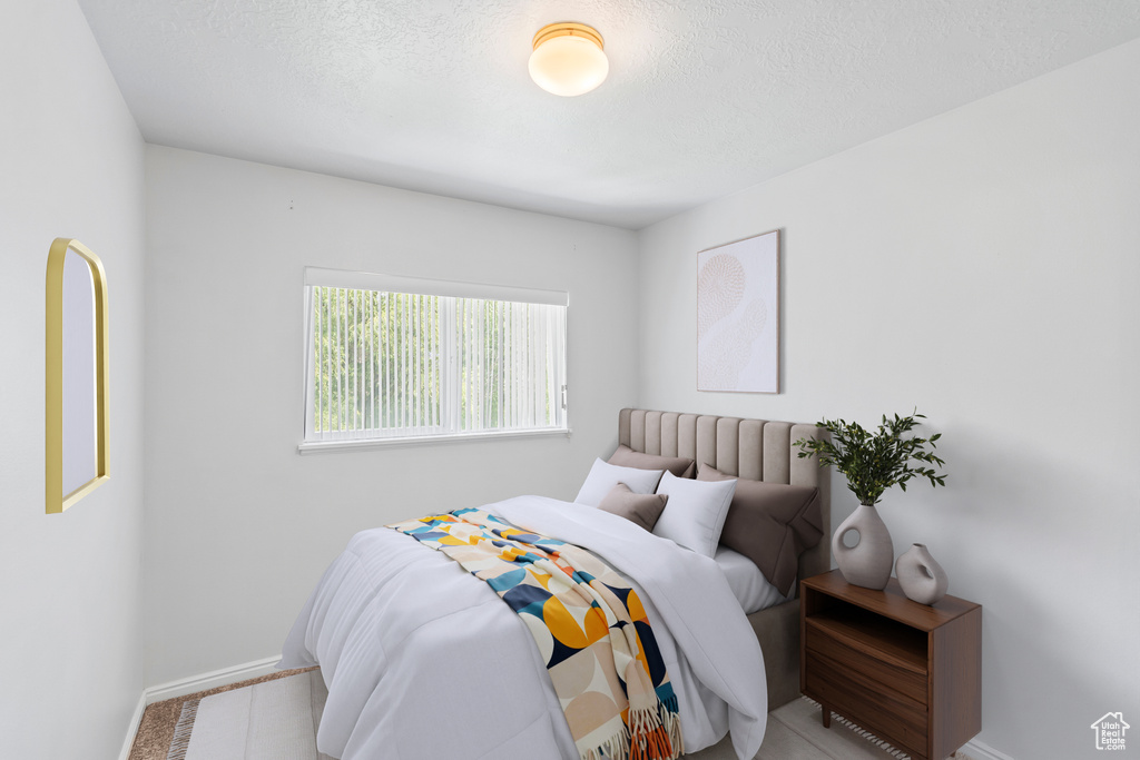 Bedroom with baseboards and a textured ceiling