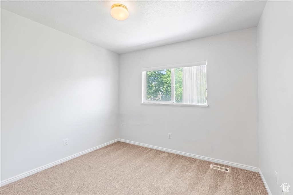 Empty room with carpet and baseboards