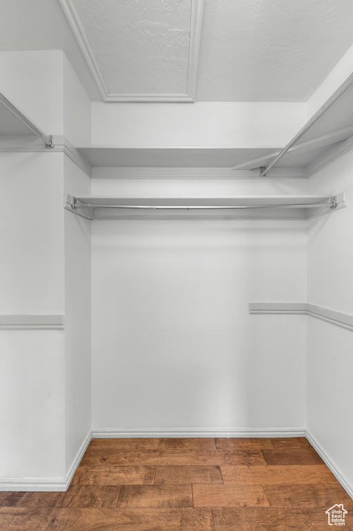 Walk in closet with wood finished floors