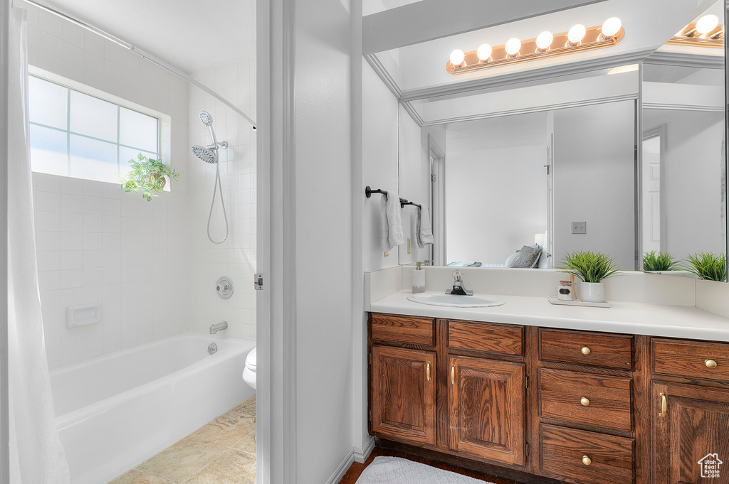 Ensuite bathroom featuring toilet, vanity, and shower / washtub combination
