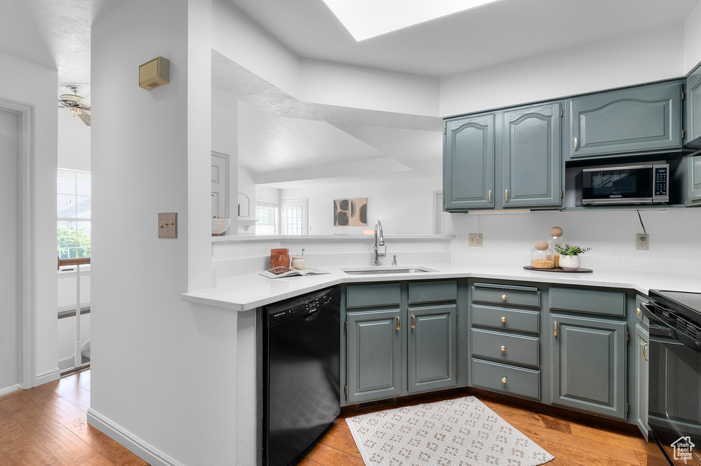 Kitchen with dishwasher, a sink, stainless steel microwave, stove, and light countertops