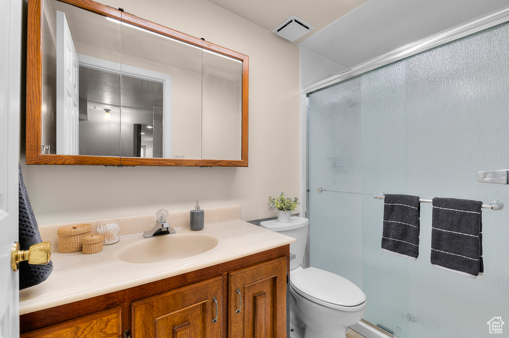 Bathroom with toilet, a shower stall, and vanity