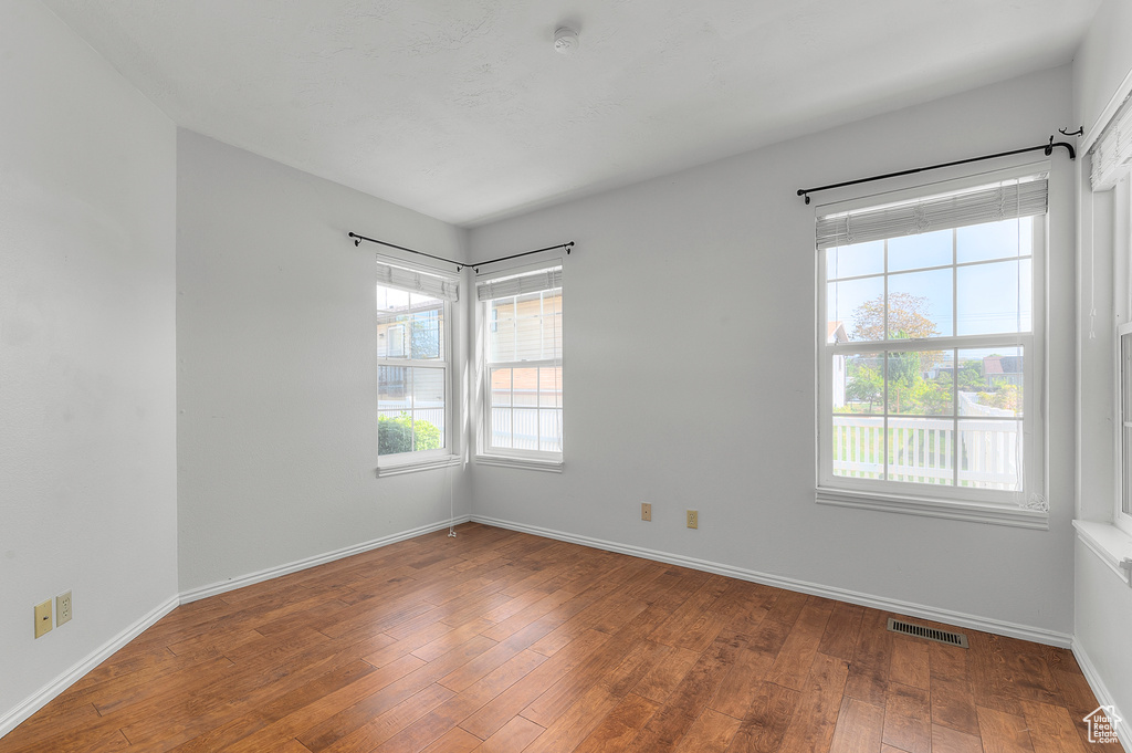 Empty room featuring hardwood / wood-style floors and baseboards