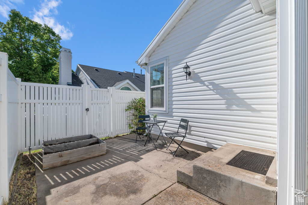 View of patio with fence and a gate