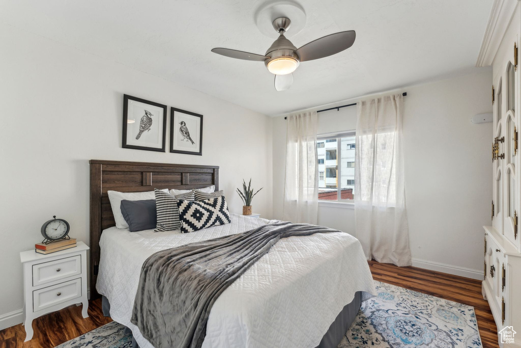 Bedroom featuring wood finished floors, baseboards, and ceiling fan