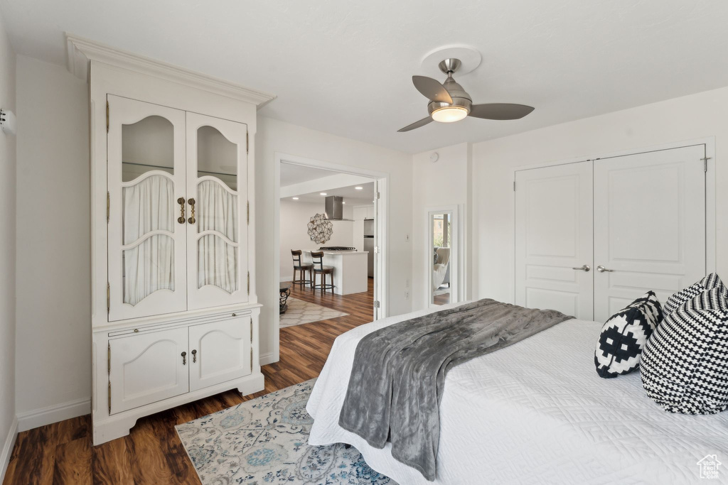 Bedroom featuring dark wood-style flooring, baseboards, ceiling fan, and a closet