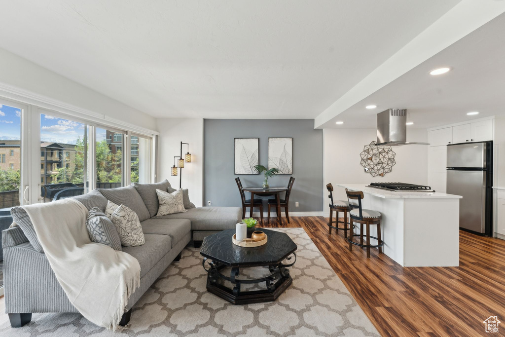 Living area with recessed lighting, wood finished floors, and baseboards