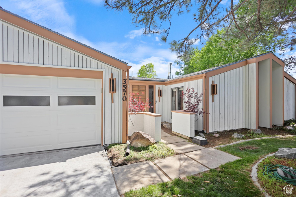 View of front facade featuring a garage and driveway