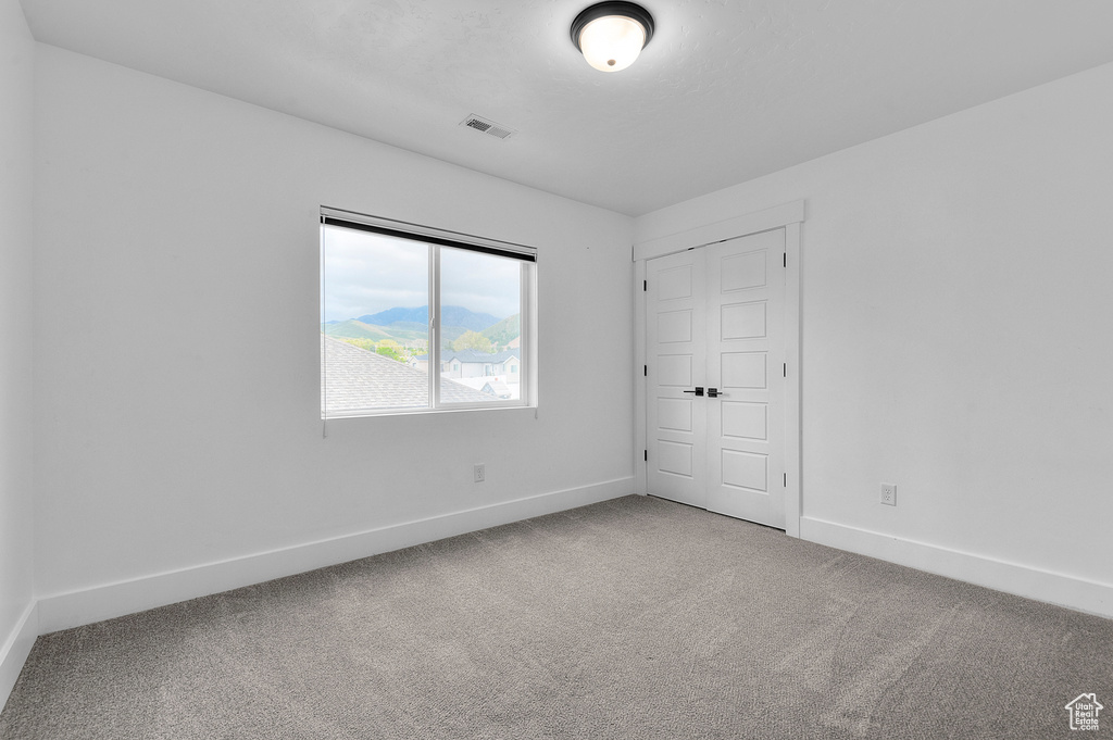 Unfurnished bedroom featuring carpet and baseboards