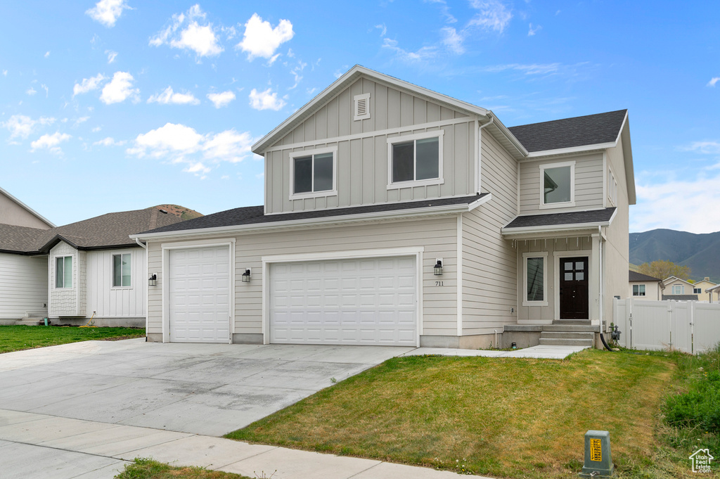 View of front of house featuring board and batten siding, driveway, and a mountain view