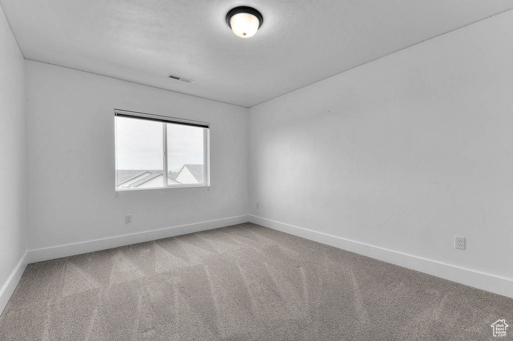 Carpeted spare room with baseboards