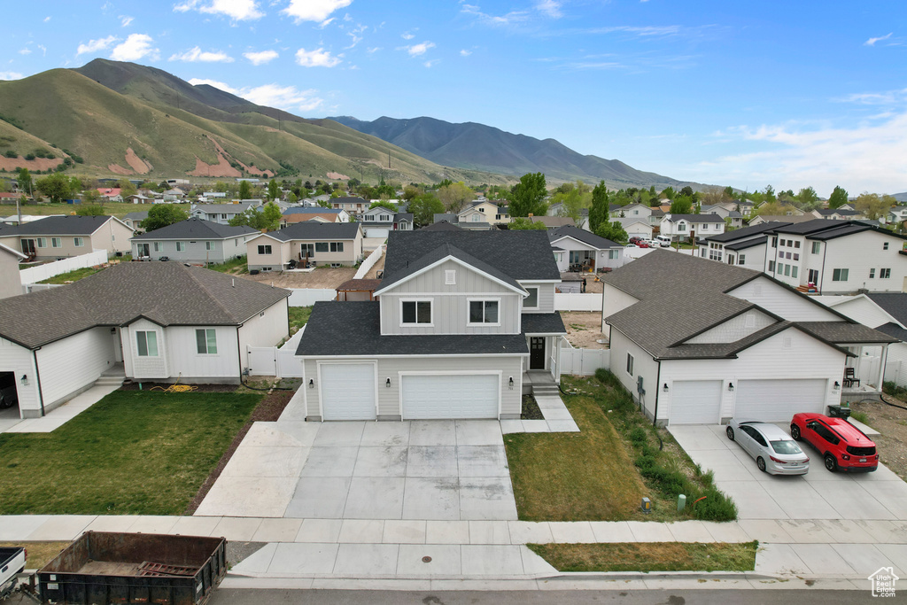 View of front of home featuring a residential view, concrete driveway, board and batten siding, and a garage