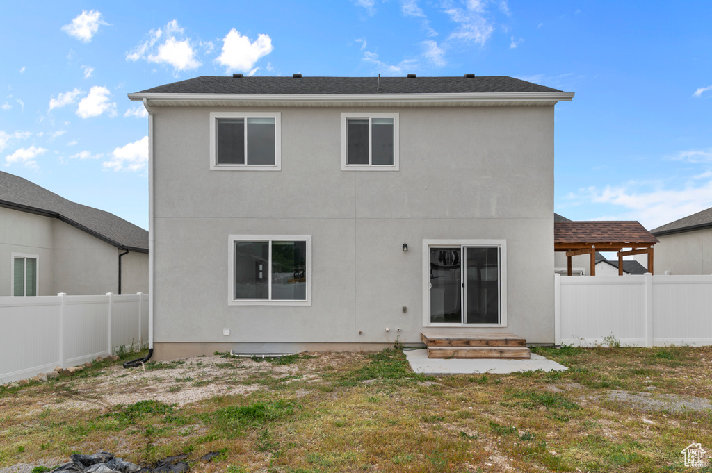 Back of property featuring a fenced backyard, entry steps, and stucco siding