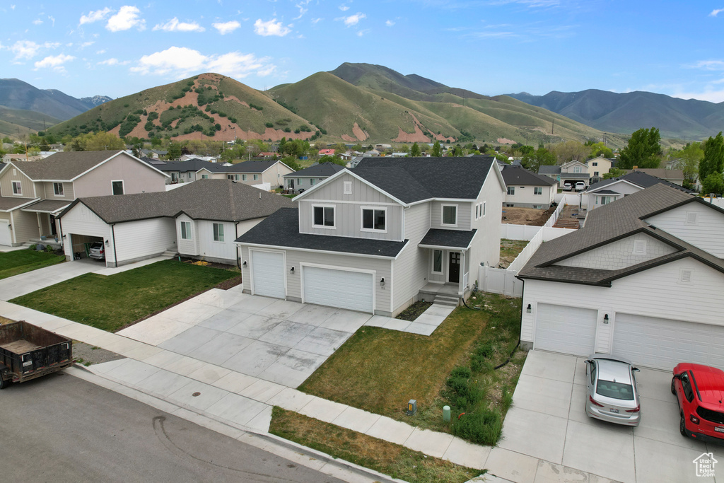 View of front facade with a residential view, concrete driveway, and board and batten siding