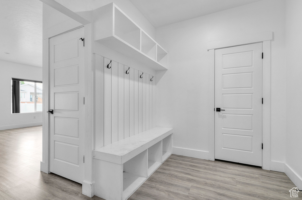 Mudroom with light wood-style floors and baseboards