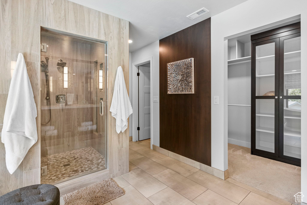 Full bathroom with a shower stall, baseboards, and tile patterned flooring