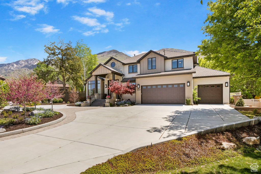 View of front of house featuring concrete driveway, board and batten siding, a mountain view, a garage, and an attached garage