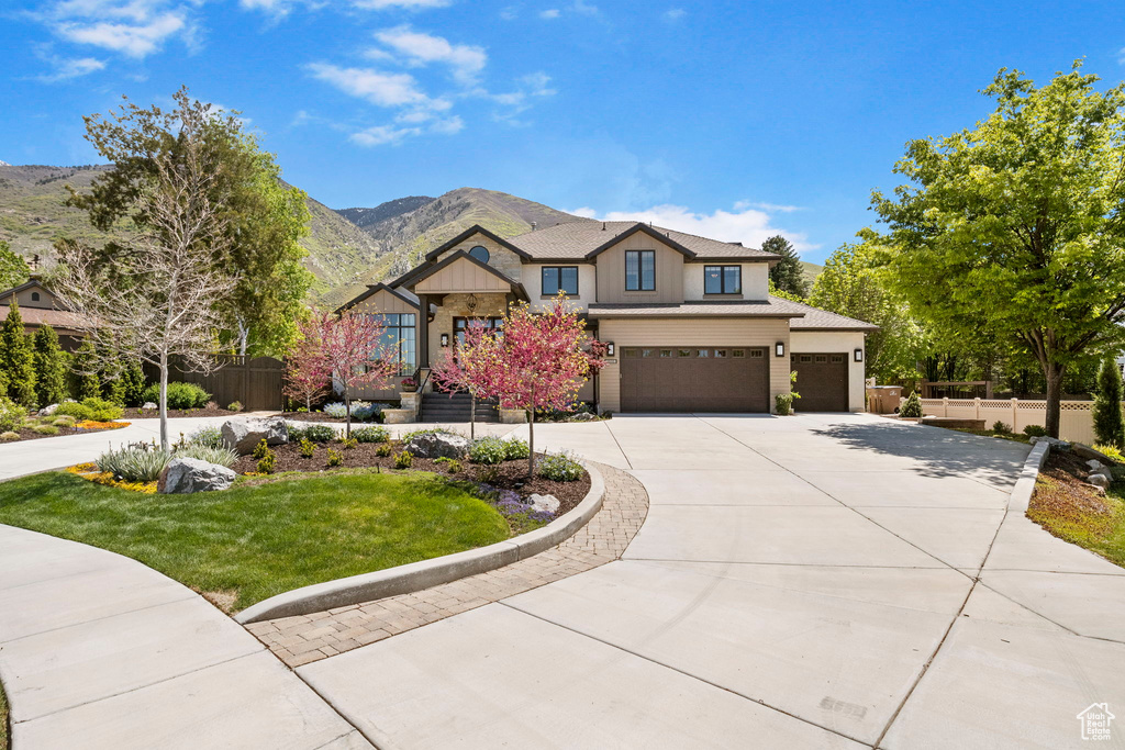 View of front of property with concrete driveway, a garage, a mountain view, and board and batten siding