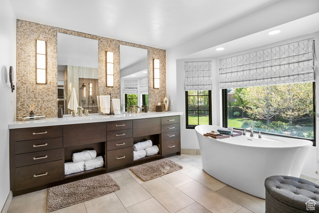 Full bath featuring vanity, a freestanding tub, and recessed lighting