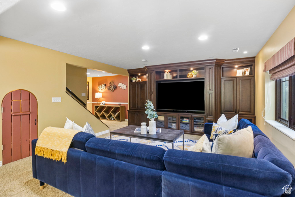 Living area featuring carpet floors, recessed lighting, and stairway